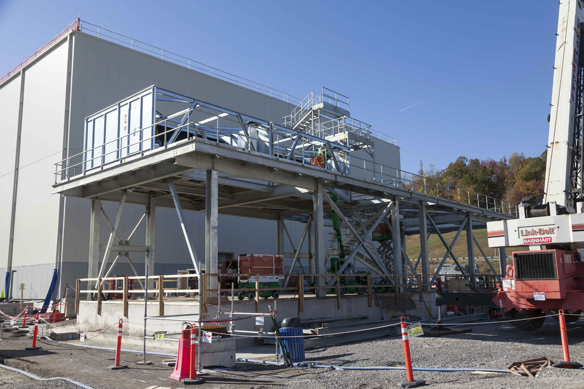 The cooling tower continues to rise next to the Uranium Processing Facility Mechanical and Electrical Building.