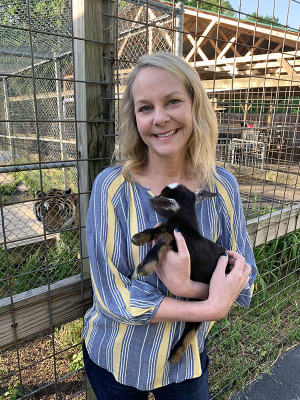 Y-12’s Denise Harmening nestles a baby goat at Little Ponderosa Zoo and Rescue." title="Y-12’s Denise Harmening nestles a baby goat at Little Ponderosa Zoo and Rescue