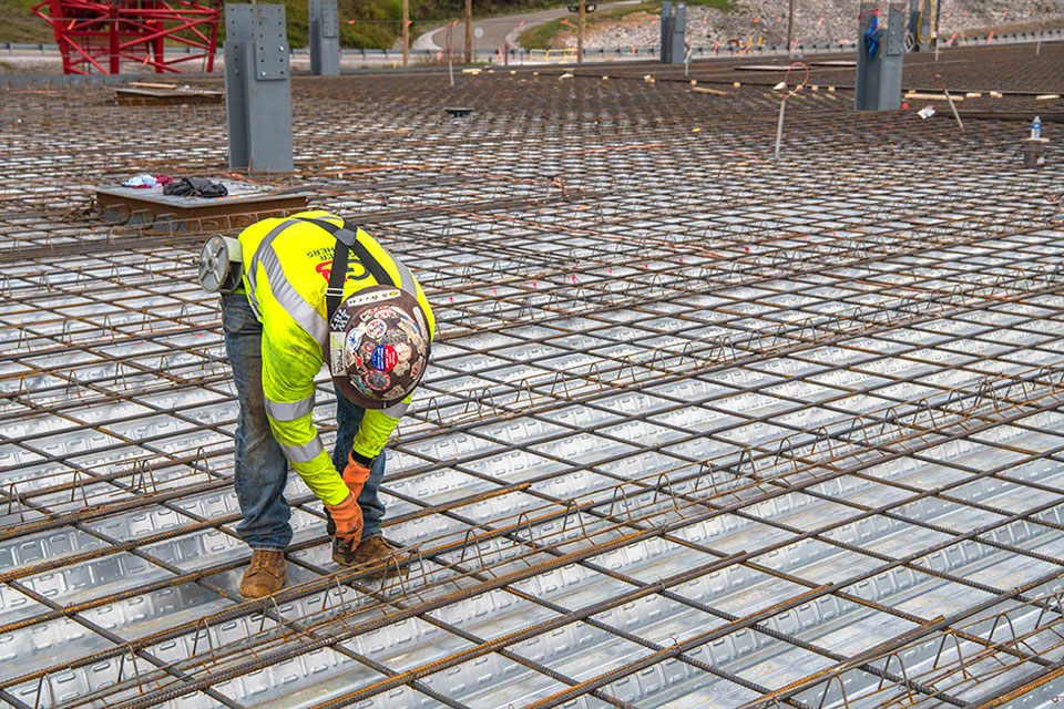 An ironworker ties rebar on the second level of the Mechanical Electrical Building in preparation for elevated concrete placement and structural steel for the second floor.  