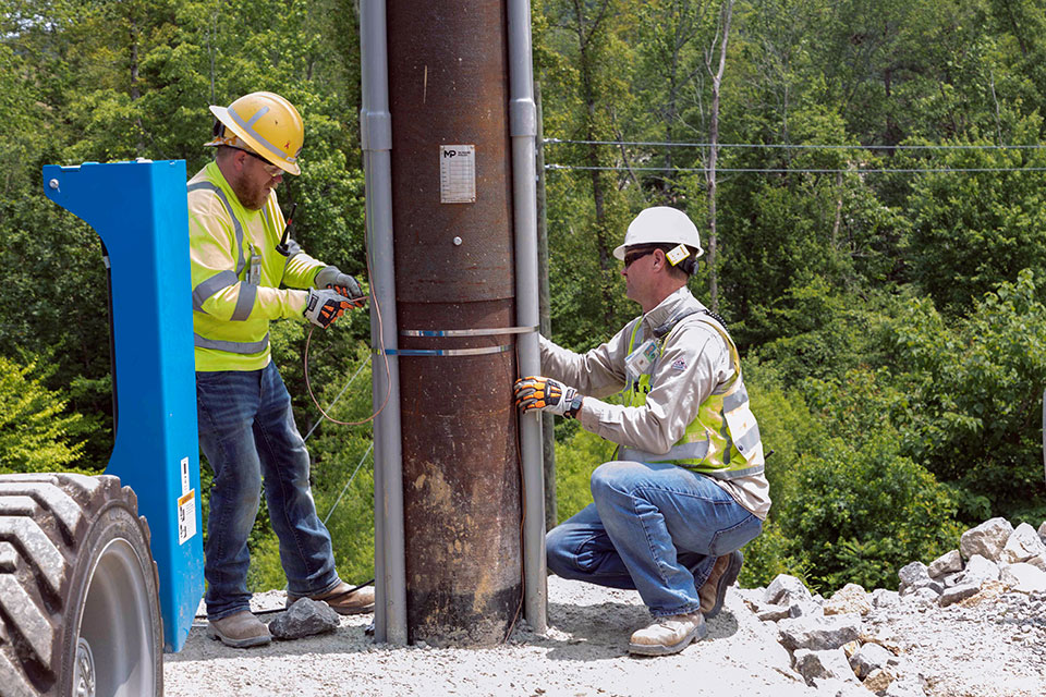 Ground wire installation takes place on a communications line at the Uranium Processing Facility Substation.