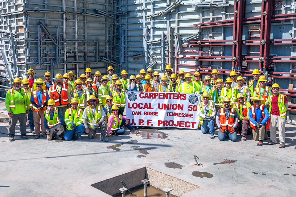 Carpenters on the Construction crew gather to celebrate the completion of first level walls at the Uranium Processing Facility Main Process Building.