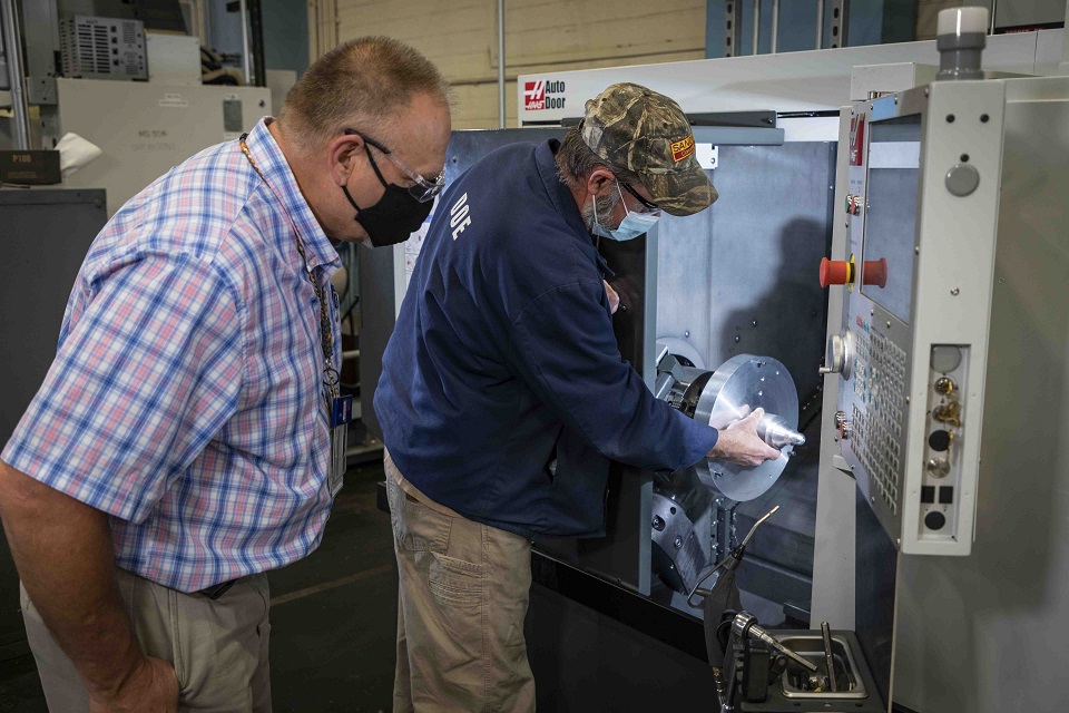 Production specialist Wendell Laughter, left, and machinist Mike Montgomery