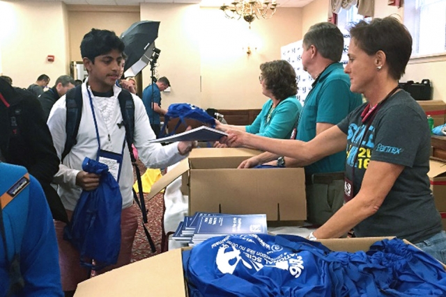 Pantex’s Darla Fish greets an Ascension Academy student as teams check in for the National Science Bowl® at the National 4-H Youth Conference Center in Maryland.
