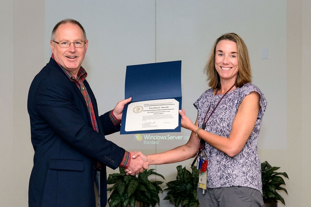 Melanie Dillon accepts the NNSA Excellence Award from James McConnell.