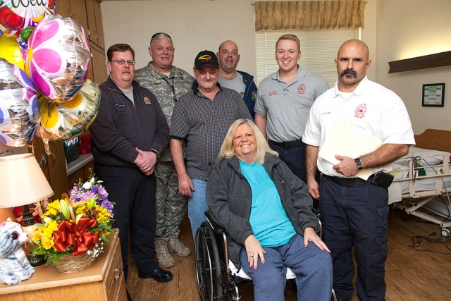 The Y-12 Fire Department paramedics and Security Police Officer who gave Freida Williford, front, lifesaving CPR visited her and her husband at the Harriman Care and Rehabilitation Center. From left behind her are, Justin Blackstock, Joe Perian, Keith Williford, Rick Dettmering, Brad Holt and Loyd Williams.