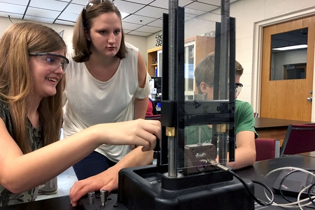Materials camp participants work with their graduate-school mentor to perform tensile testing in a lab at Pellissippi State Community College. 