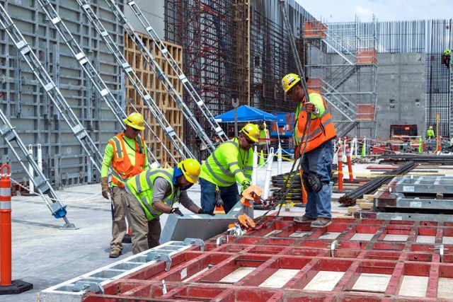 Carpenters assemble wall formwork sections before lifting them into place at the Main Process Building.