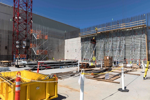 Now that the first vertical wall has been placed at the Main Process Building, additional forms are added on to the inside and outside of the rebar wall curtain to prepare for the next concrete placements.