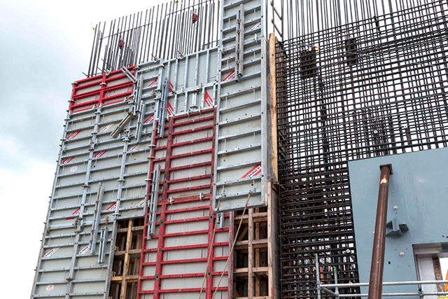 Forms are installed on the outside of a rebar wall curtain at the Main Process Building (MPB). Once inside and outside forms are installed, concrete is placed to construct the outside wall of the MPB. 
