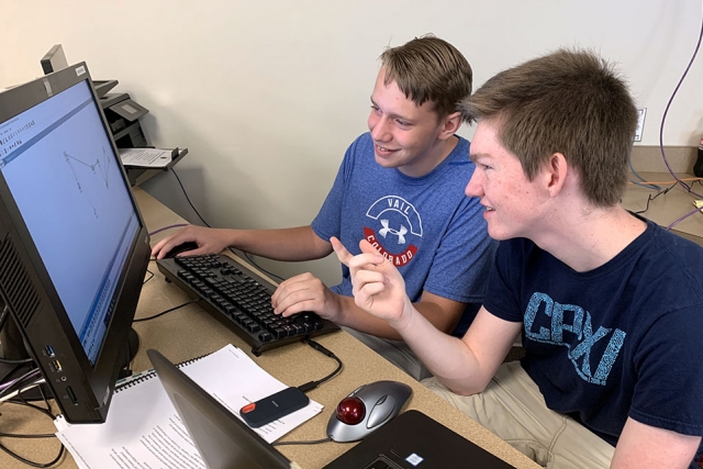 Cybercamp participants Justin, left, and Peter, both students at Oak Ridge High School, simulate routing a network for a small business.