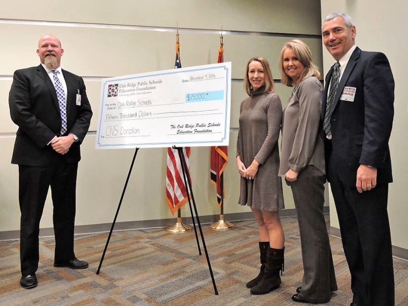 From left, Bruce Borchers, superintendent of Oak Ridge Schools, and Jessica Steed, executive director of the Oak Ridge Public Schools Education Foundation, accept a donation from Kristin Waldschlager, CNS education outreach coordinator, and Gene Sievers, deputy Y-12 site manager, to get the Navy National Defense Cadet Corps program started at Oak Ridge High School.</body></html>