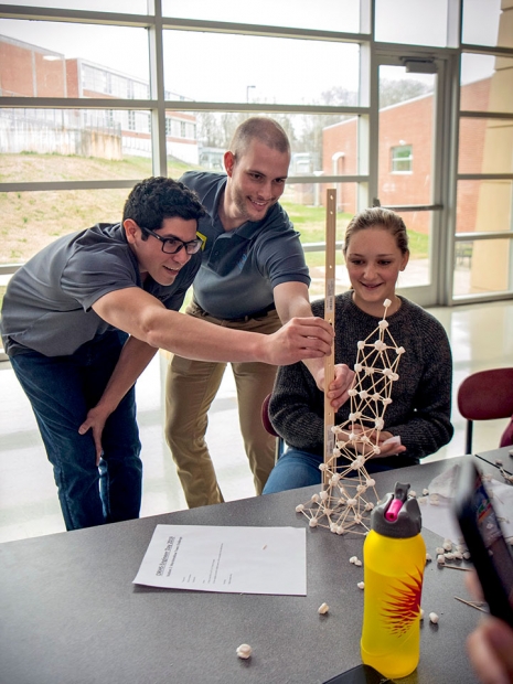 Matthew Chapa and a fellow engineer measure a student’s tower during EWeek activities at ORHS. 