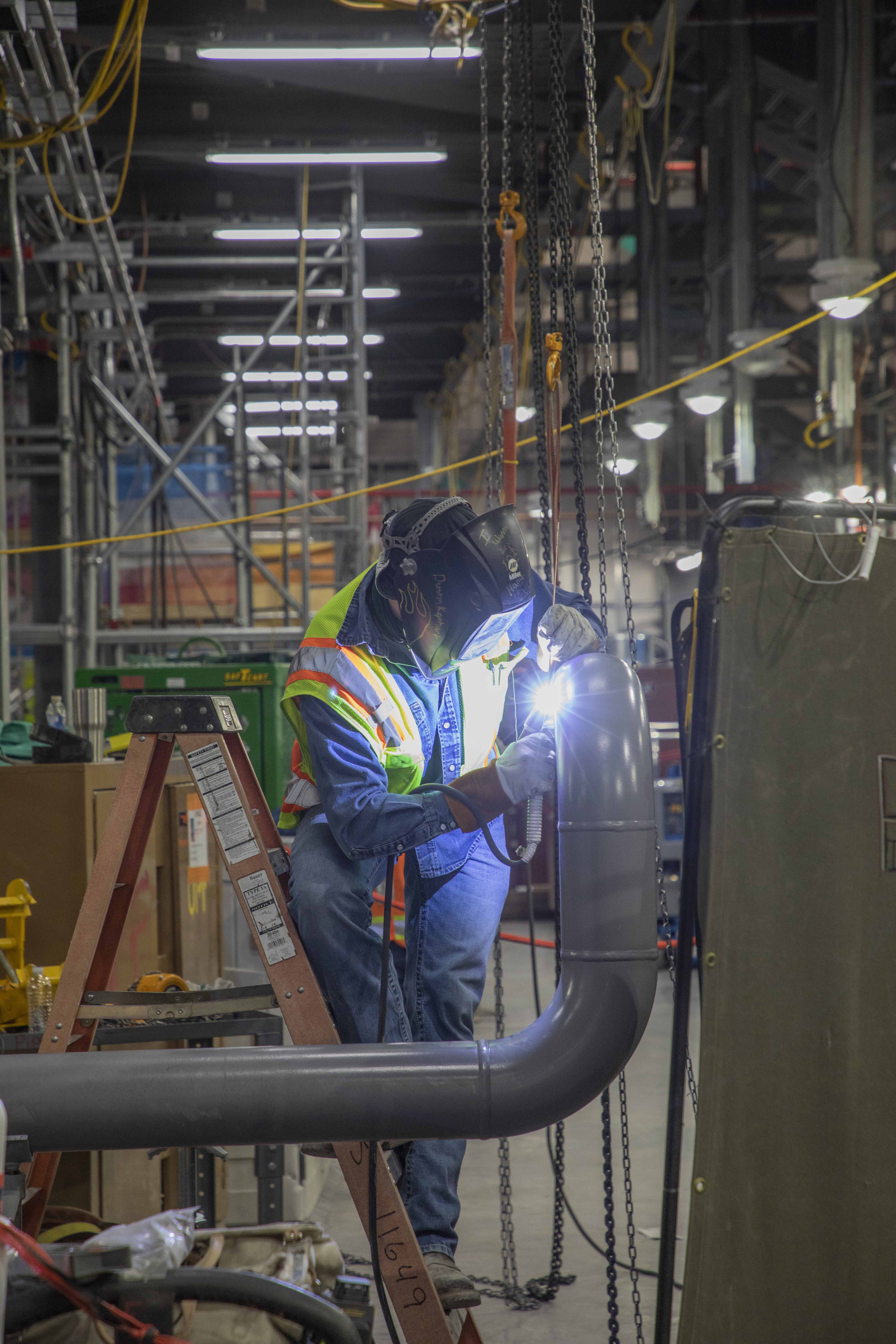 UPF Welder and Pipe Fitter works on a Mechanical Electrical Building pipe.