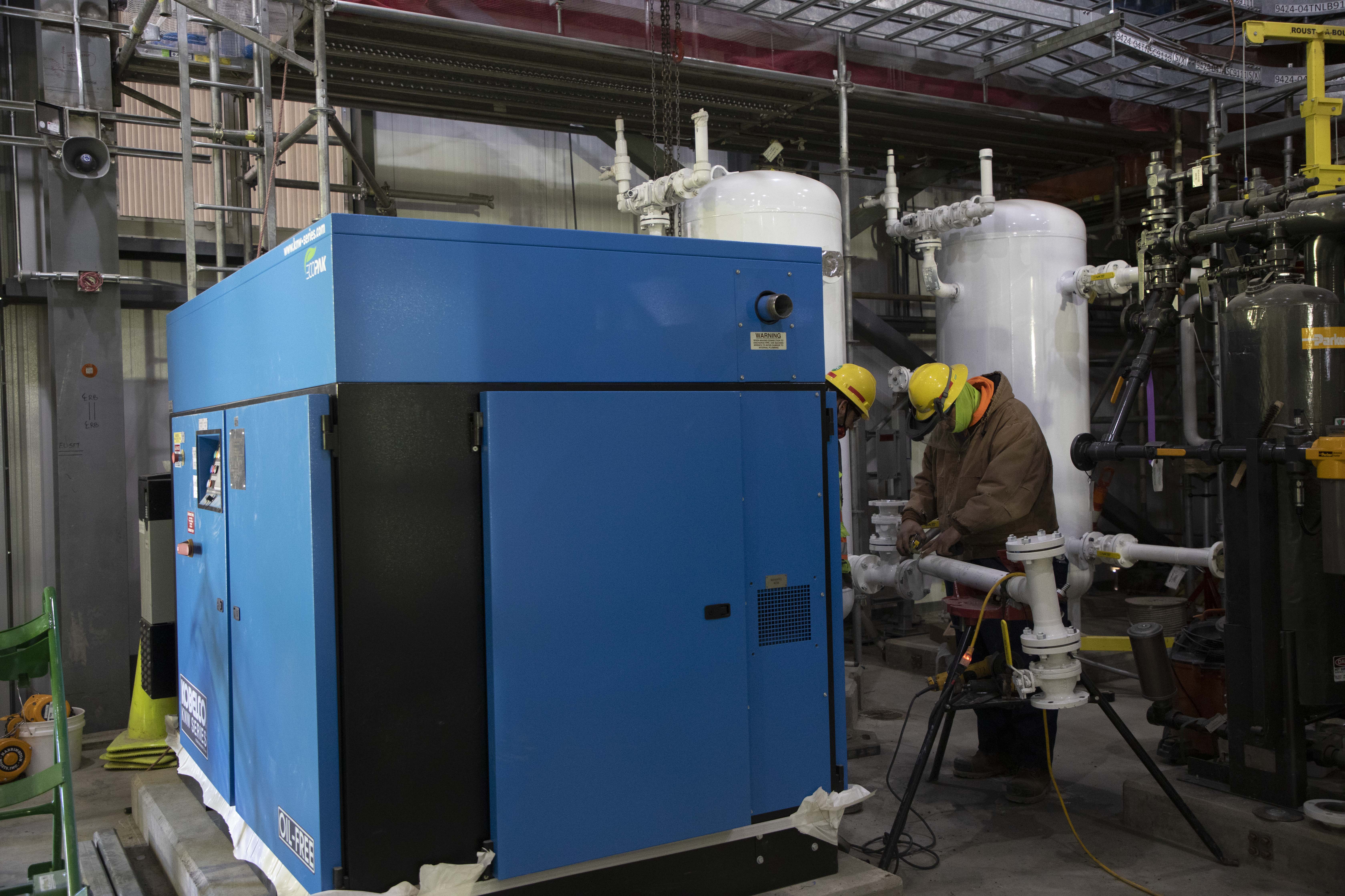 Pipefitters Installing Breathing Air System Piping in the Process Support Facilities Process Support Equipment Room