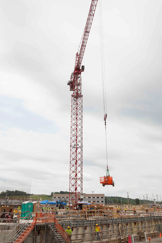 The west tower crane at the Uranium Processing Facility relocates a manlift onto the Salvage and Accountability Building foundation.