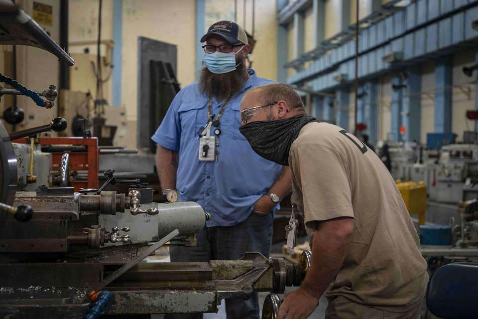 Kevin Lewis (left), a production support specialist, and machinist Matt Bumbalough