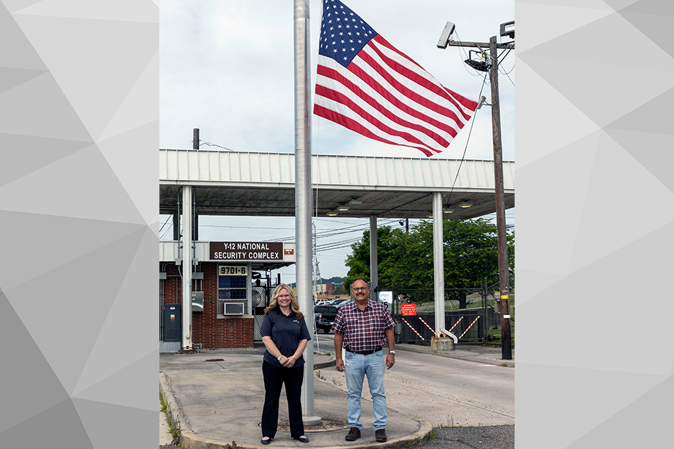 Jan West (left) and Jeff Barnard (right) stand in front of the new flag at Post 5.
