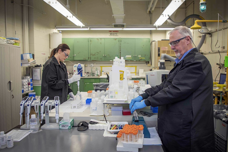 ACO personnel prepare samples for an inductively coupled plasma‑optical emission spectrometry instrument.