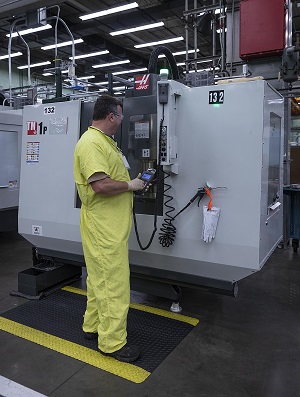 A machinist works at the Haas TM1 milling machine