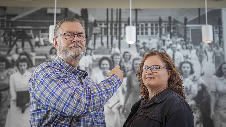 Doug C. points out his grandmother, Marie Guy, pictured in a mural on the Jack Case Center cafeteria wall. Photo by Jordan R.
