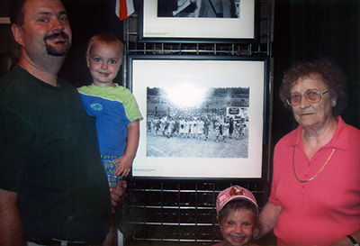 Doug C. and Marie Guy pose for a family photo in front of a copy of Ed Westcott’s “Y-12 Shift Change” at the American Museum of Science and Energy in Oak Ridge. (Submitted)