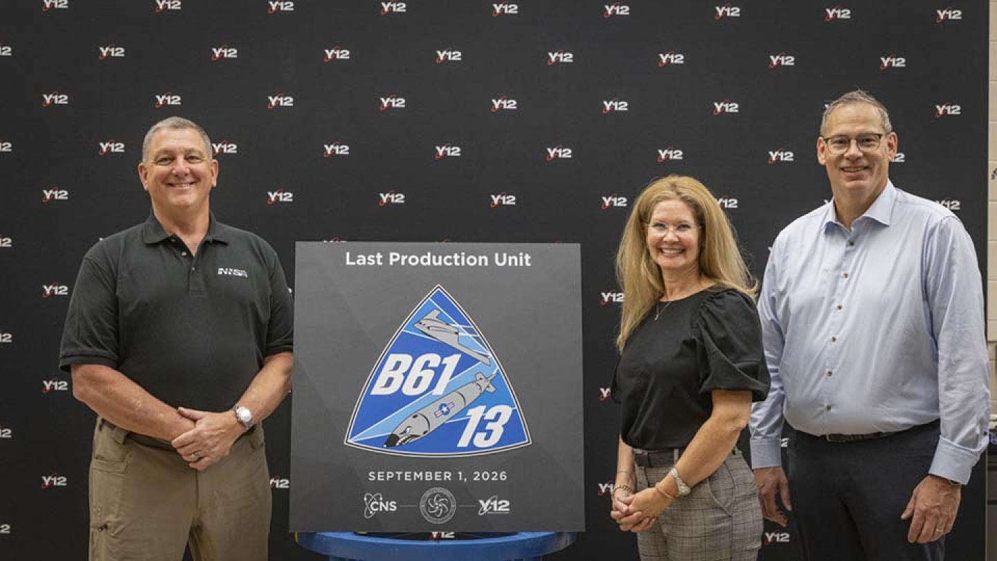 From left: NNSA Principal Deputy Administrator Scott Pappano, Manager of NNSA's Y-12 Field Office Mary Helen Hitson, and CNS President & CEO Todd Ailes pose in front of a display that shields a newly diamond-stamped B61-13 CSA from view.