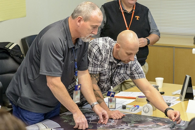 Jeff Knott and Casey Cole (both of Y-12) make crucial moves on the battle board for the protective (blue) team.