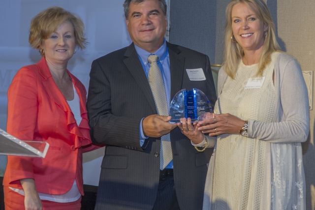 Jorge and Deana Sanabria accept the CNS Small Business of the Year award from Y-12 Socioeconomic Program Manager Lisa Copeland (at left).