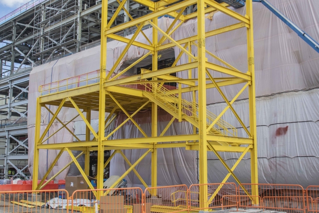 Bright yellow temporary steel was installed on the outside of the Salvage and Accountability Building this month, which will allow large pieces of equipment to enter the facility after siding is installed.
