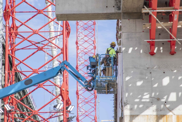 UPF ironworker inspects a second elevation concrete wall on the Main Process Building.