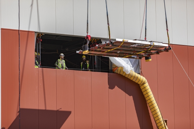 Salvage and Accountability glovebox team drifting the CAL WIE panels through the Personnel Support Building Level 2 window in preparation for installation 