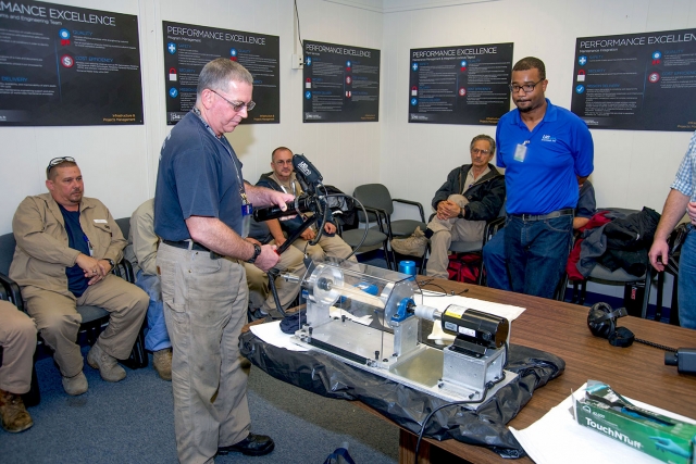 Y‑12 craftsmen learn how to use a grease caddy for ultrasound lubrication.