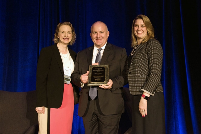 Nancy Jo Nicholas, (at left) INMM Fellows Committee chair, recognizes Hassler as INMM Fellow, along with Corey Hinderstein, INMM president 