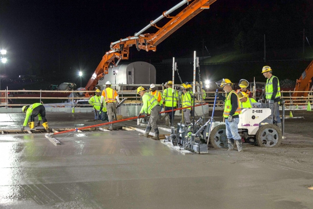 Cement finishers smooth out part of a 885 cubic yard concrete placement at the Salvage and Accountability Building (SAB). It was the final topping slab placement for the SAB.