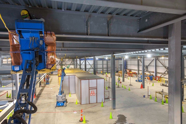 A Uranium Processing Facility team member places one of the final white steel shear tabs on the first floor of the Mechanical Electrical Building.