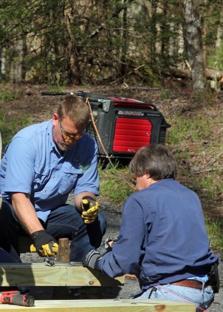 Y-12 Infrastructure Manager Scott Underwood and Y-12 retiree George Dailey work on the amphitheater at the Elkmont Campground. 